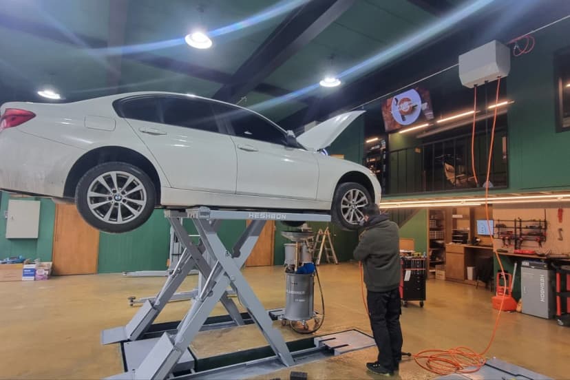 리프트에 올린 BMW 세단 하부 정비 작업 — 카에프제트 아우토하우스